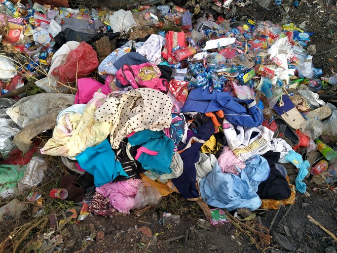 A pile of dirty clothes discarded with rubbish