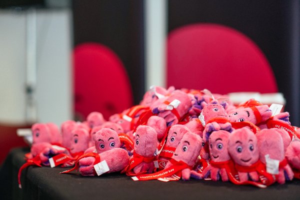A pile of pink, soft toy octopuses on an office desk