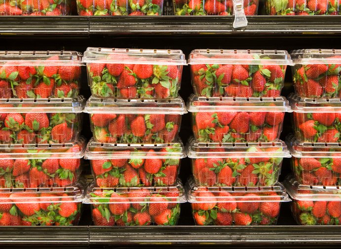 Strawberries in plastic containers on supermarket shelf