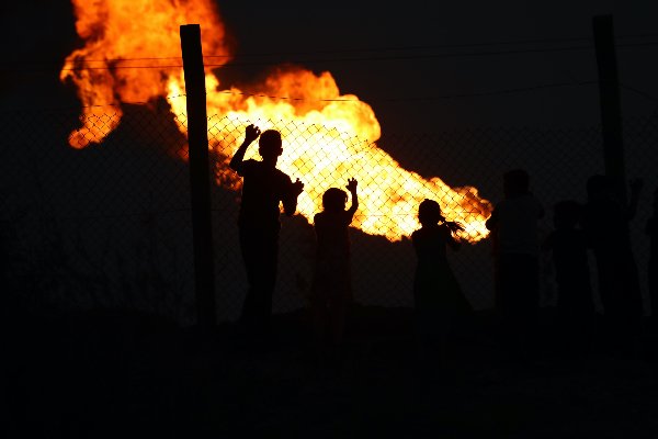 Children at the fenceline of a gas compression station in Nahran Omar, near Basra