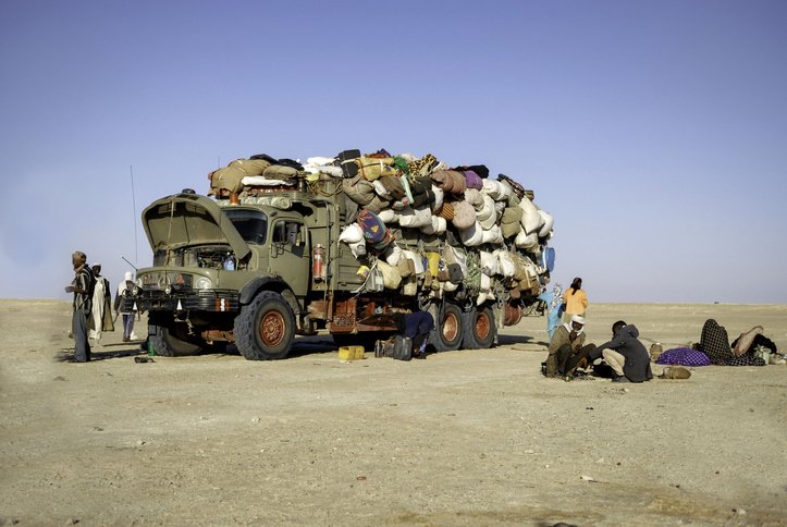 A group of immigrants in the desert of Chad, close to a border when the truck full of goods breaks down