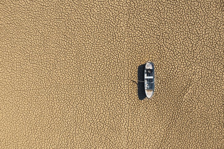 Aerial view of a single fishing boat on the dry surface of a drought lake bed in Burdur, Turkey