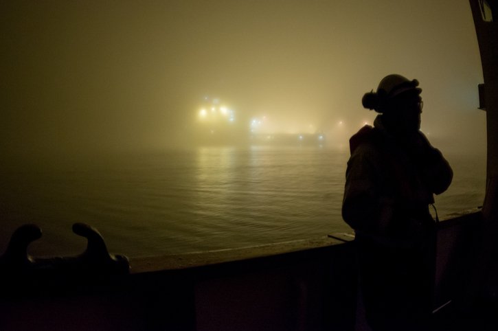 North Sea oil rig worker at sea on a foggy dark night