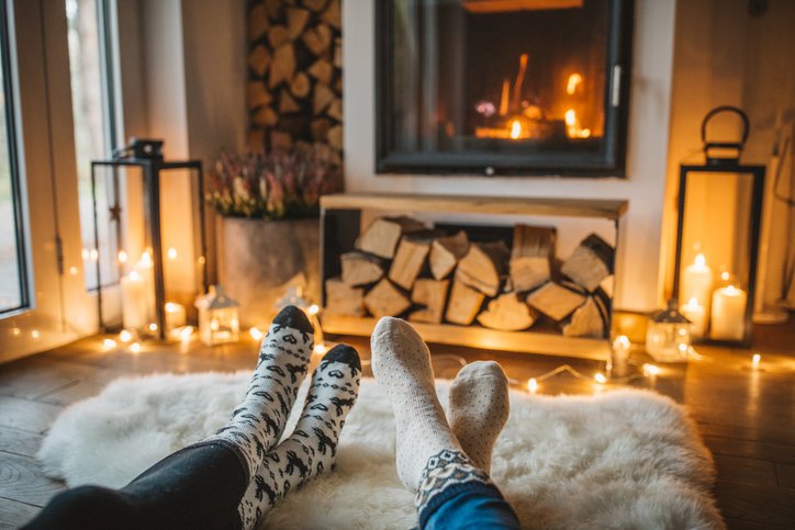 View of couple's feet (in socks) as they relax at home in front of a fire