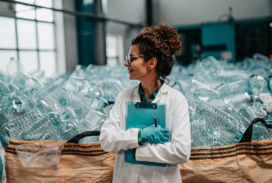 Young, happy female worker in bottling factory recycling department