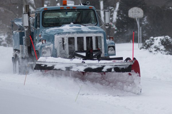 A Babylon village snowplow clearing a residential street during the blizzard of 2022 on Long Island New York
