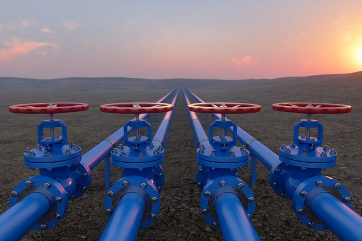 Oil Or Gas Transportation With Blue gas pipeline with valves stretching across the land and into the sunrise on the horizon