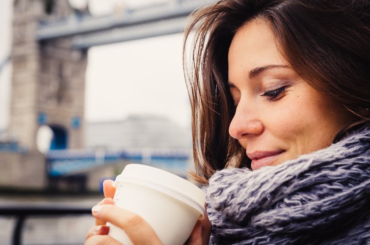 Young Woman Drinking Coffee Near Tower Bridge In London
