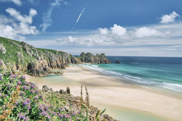 Scenic views across Pedn Vounder Beach towards Logan's Rock, Cornwall on a sunny June day