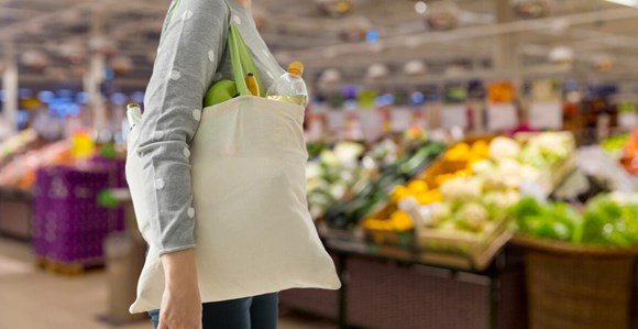 A lady shopping in a supermarket with a canvas tote