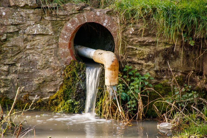 Water flowing from drain into river
