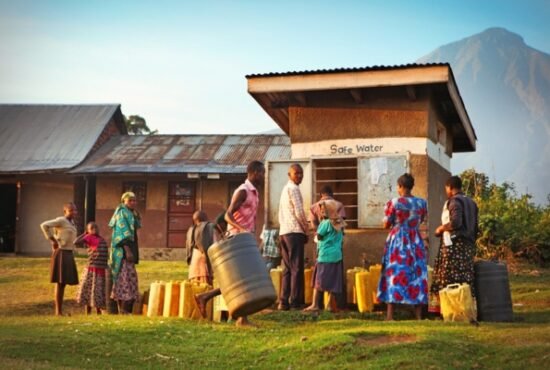 Local villagers waiting with plastic canisters to get safe water from public water well in Nyarusiza, Uganda