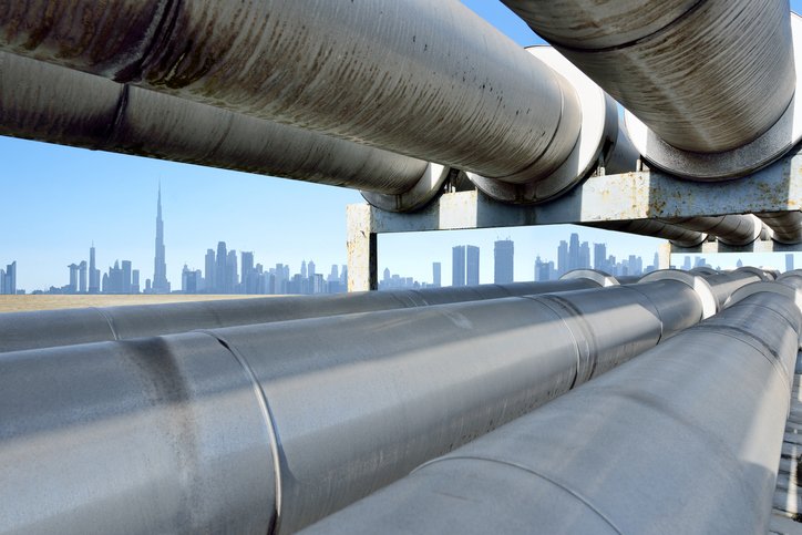 Oil pipeline reflecting Dubai skyline, United Arab Emirates