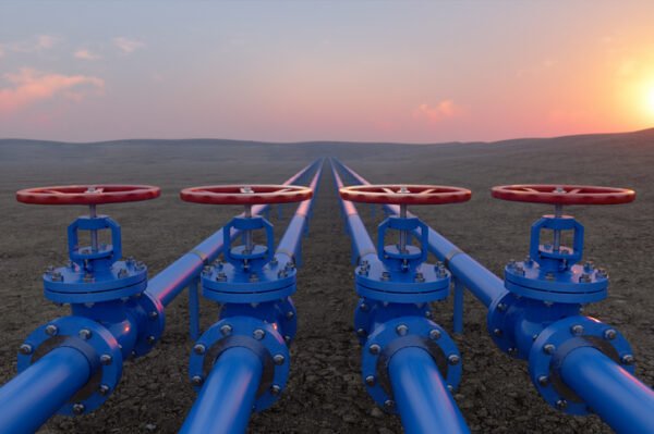 Pipeline valves on soil, with sunrise in the background