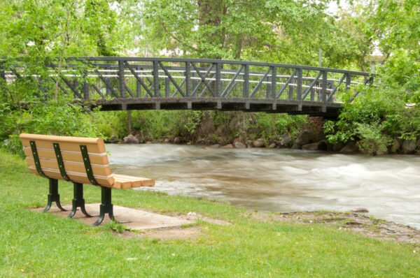 Boulder Creek Bridge in downtown Boulder Colorado, with a bench in the foreground