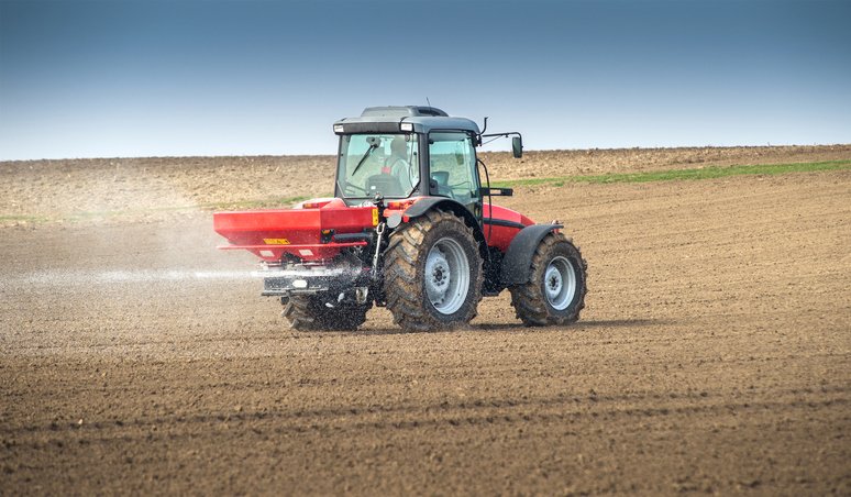 Tractor and fertiliser spreader in field