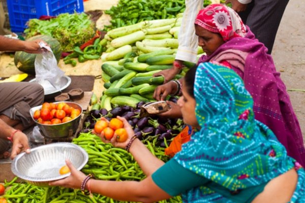 Women selling fruit and veg at a market in Jaipur, India