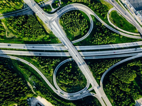 Aerial view of highway and overpass with green woods on a summer day in Finland.