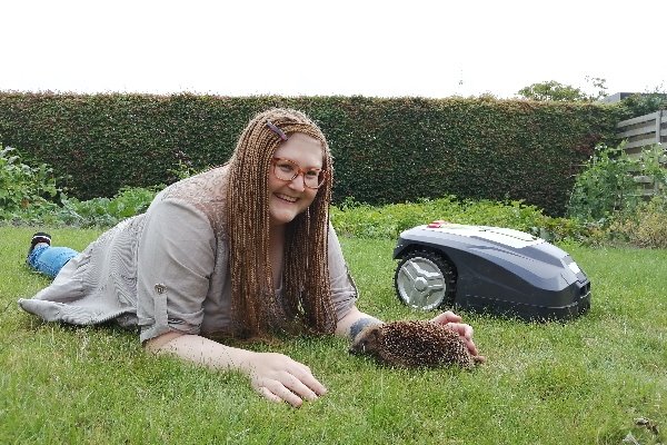 Sophie with hedgehog and robotic lawn mower_Credit Troels Pank