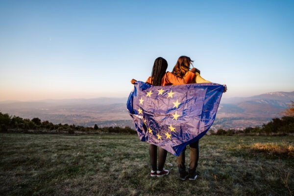 Two multi-ethnic women holding European Union flag