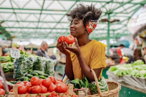 Young African woman buying tomatoes at the market