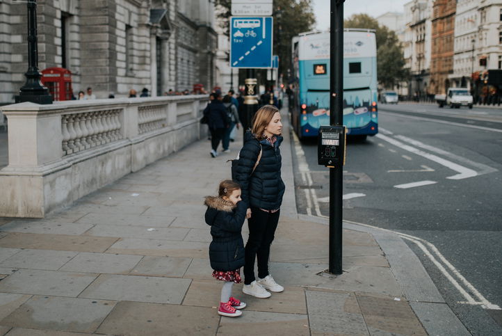 Mother holding her daughter's hand before crossing the street in London, England.