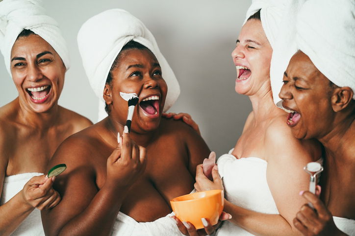 Multigenerational women having fun applying face beauty masks on their face
