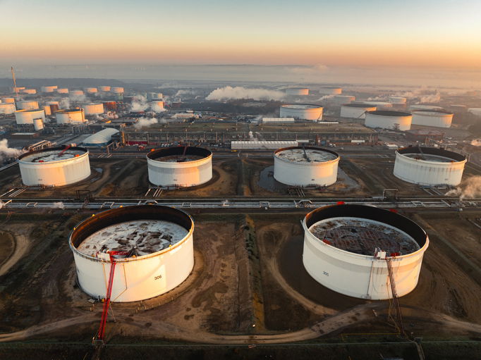 Aerial view of fawley oil refinery emitting smoke and steam at sunset