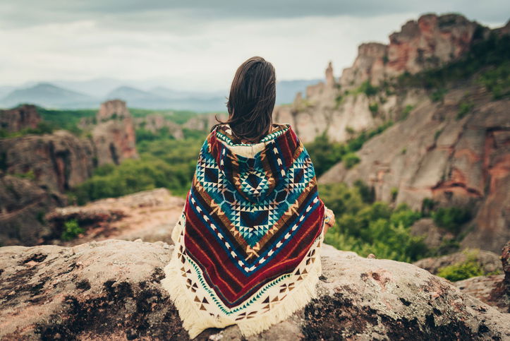 Shaman woman with arms outstretched, meditating in the mountains
