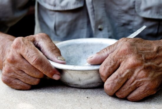 Poor old man's hands an empty bowl