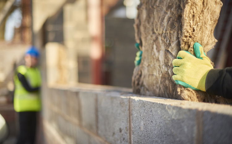 Close up of a builder installing cavity insulation
