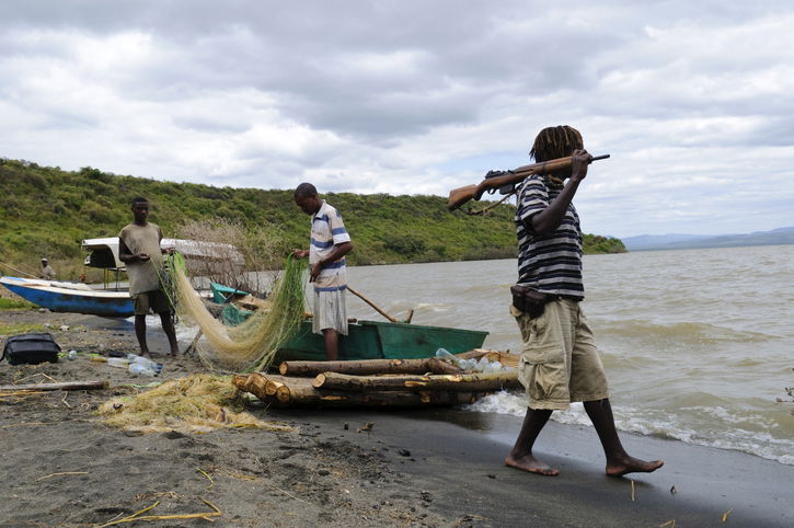 In Nechisar National Park, not far from the town of Arba Minch, three Ethiopians stand on the lakeshore. Two are tending to a fishing net. One other is walking with a rifle on his shoulder, carried for self-defence due to the history of tribal conflict in the area