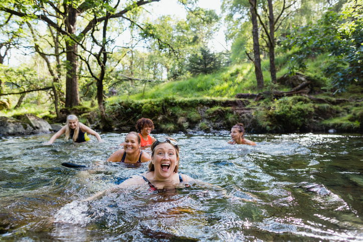 Group of women wild swimming in the Lake District, North West of England