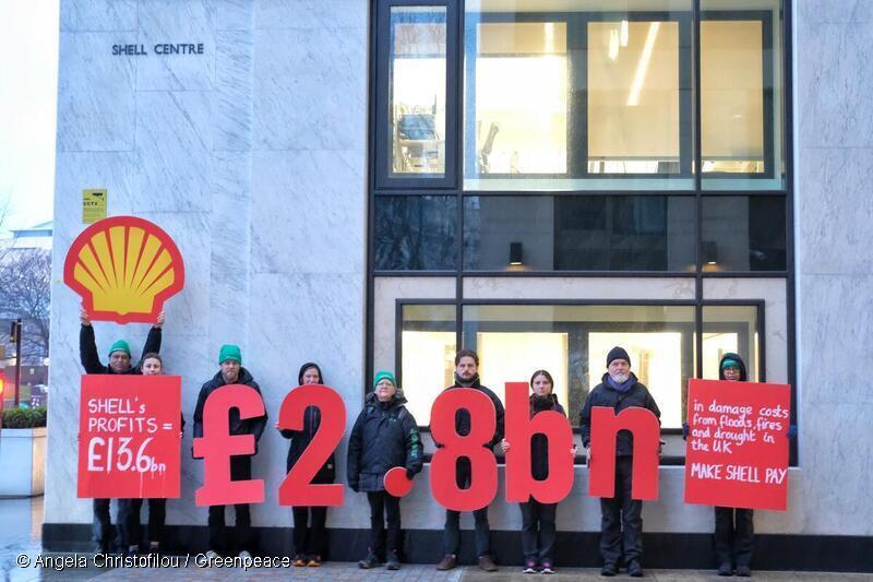 Greenpeace UK activists stage a protest outside Shell’s London HQ, holding giant figures comparing Shell’s annual profit with the UK’s 2025 bill for damages caused by extreme weather following the oil giant’s profit announcement