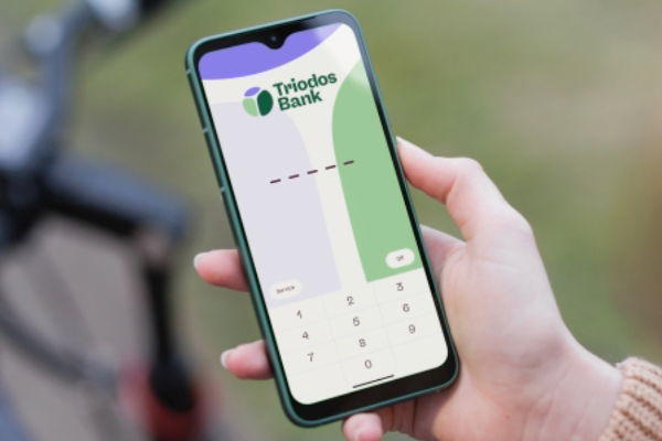 woman holding mobile phone, with screen showing Triodos Bank's log-in page