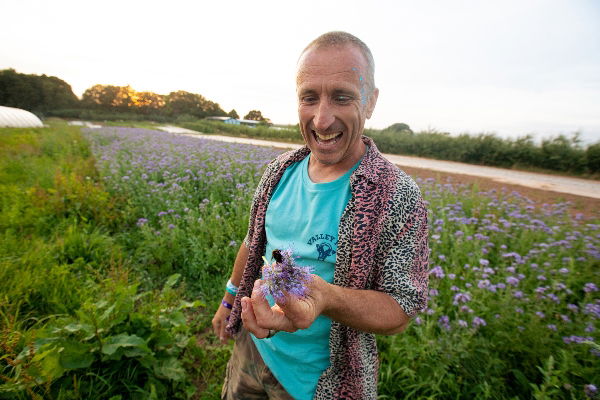 Luke Hassell with a bumble bee at his farm in Somerset